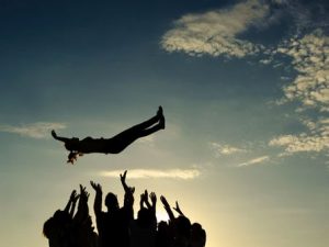 Group throwing a person into the air